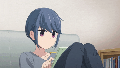 a blue haired anime girl is sitting on a couch looking at a tablet