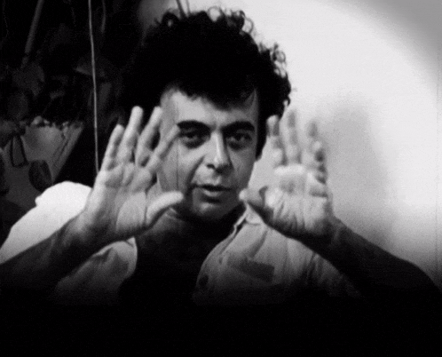 a black and white photo of a man making a stop sign with his hands