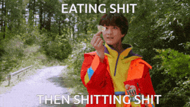a man in a red and yellow jacket is eating a piece of food with the caption " eating shit then shitting shit "