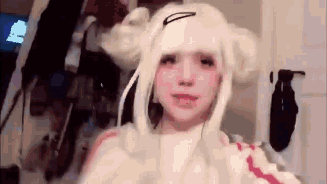 a girl wearing a white wig is taking a selfie in a room .