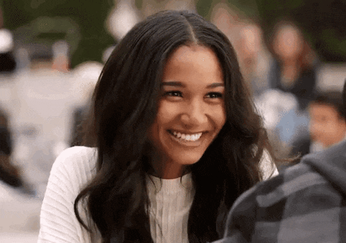 a woman is smiling while sitting next to a man .