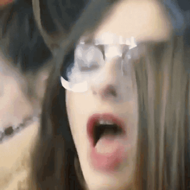 a close up of a woman 's face with glasses on