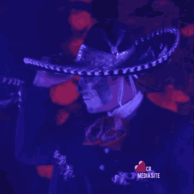 a man wearing a sombrero is standing in front of a red heart that says cr mediasite