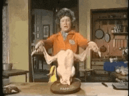 a woman is holding a dead duck on a plate in a kitchen .