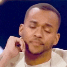 a close up of a man with his hand on his chin .