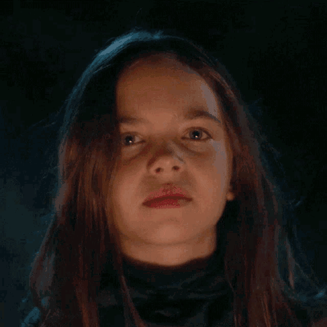 a close up of a young girl 's face in the dark