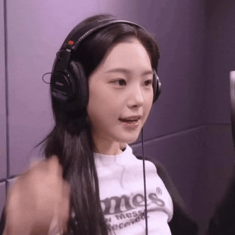 a young woman wearing headphones is sitting in a room .