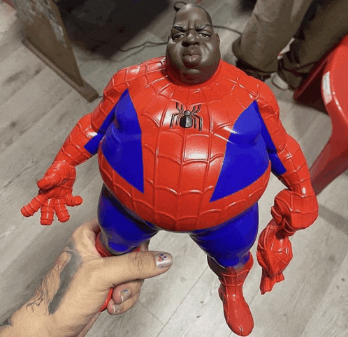 a person holding a spider man figurine with a black face