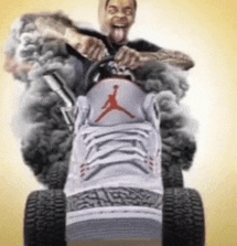 a man is riding a lawn mower with a pair of jordan shoes on it