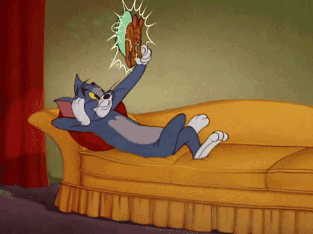a cartoon cat is laying on a couch holding a fan