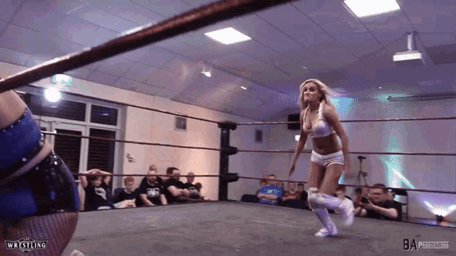 a woman is in a wrestling ring with ba productions written on the bottom