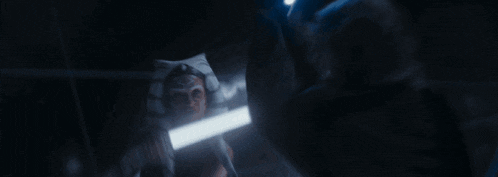 a woman is holding a light saber in front of her face
