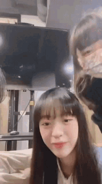 a woman with long hair is sitting in front of a tv .