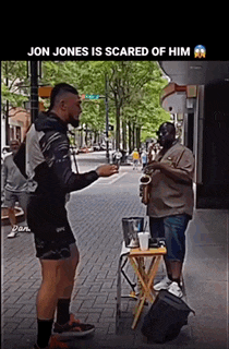 a man playing a saxophone on a sidewalk with jon jones is scared of him written on the bottom