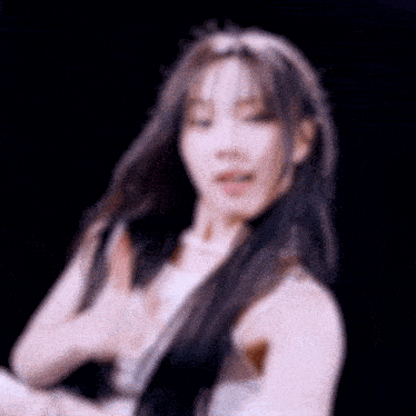 a blurry picture of a woman with long hair and a white top