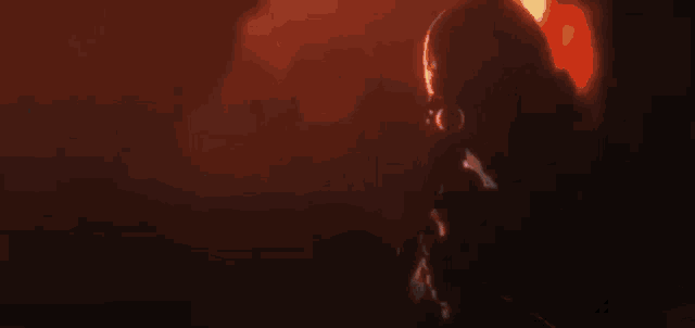a silhouette of a man smoking a cigarette in a dark room with a red background .