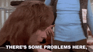 a woman says " there 's some problems here " in front of a man in a blue shirt