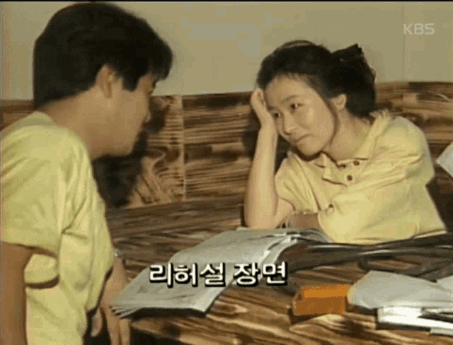 a man and a woman are sitting at a table talking in korean