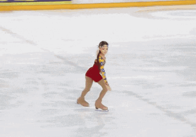 a woman in a red dress is ice skating in front of a banner that says ' tps ' on it