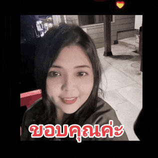 a woman taking a selfie with a heart in the background and the word ขอบคุณ written in red