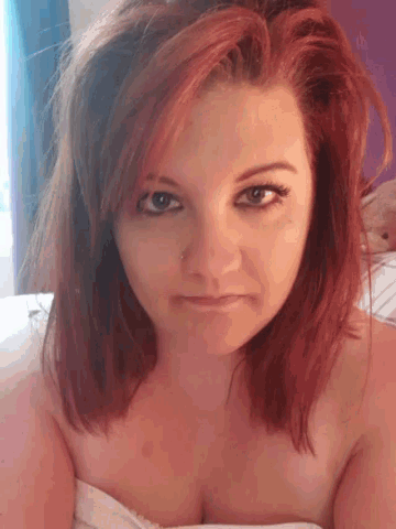 a woman with red hair has a nose ring on her nose