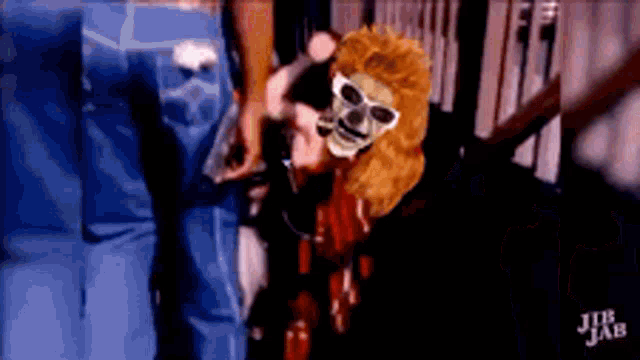 a person wearing a skeleton mask and sunglasses is standing next to a person wearing blue jeans .