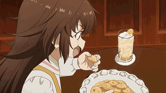 a girl is eating a cookie next to a drink