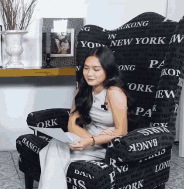 a woman sits in a chair that says new york