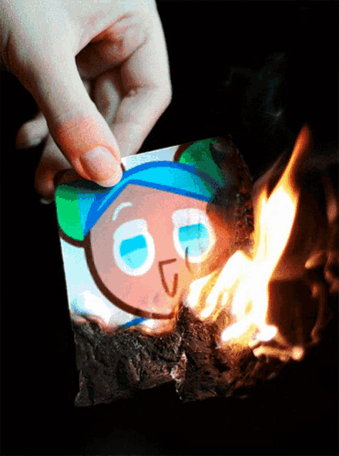 a person is holding a piece of paper with a picture of a cookie on it
