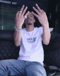 a man in a white shirt is giving the middle finger while wearing a ring