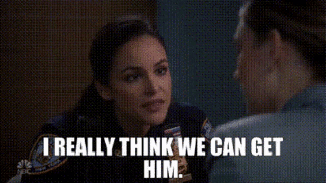 a woman in a police uniform is talking to a man in a prison cell .