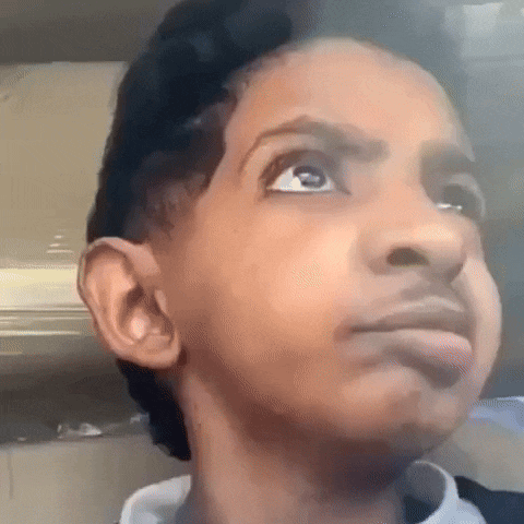 a young boy is making a funny face and looking up at the camera .