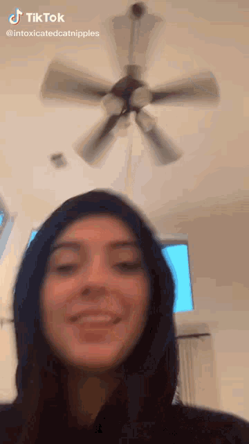 a woman is smiling in front of a ceiling fan with a tiktok watermark