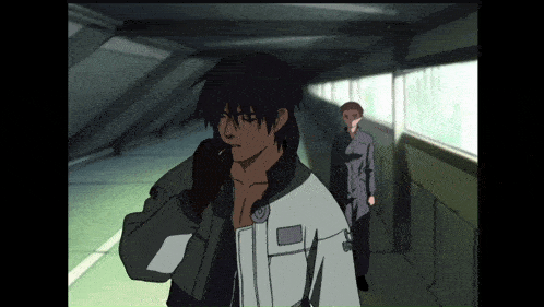 a man talking on a cell phone while another man stands behind him