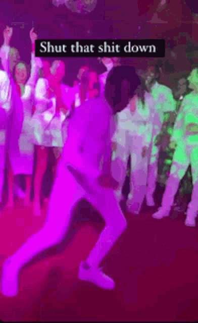 a man is dancing in front of a crowd with the words shut that shit down on the bottom