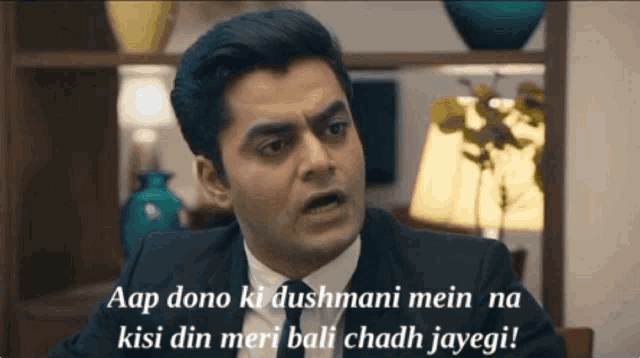 a man in a suit and tie with a caption that says aap dono ki dushmani mein na kisi din meri bali chadh jayegi