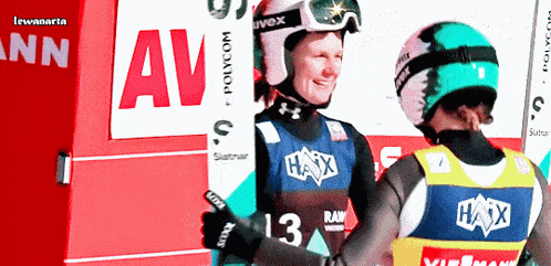 two skiers are standing in front of a sign that says av