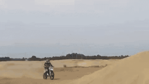 a man is riding a dirt bike on a dirt road in the desert .