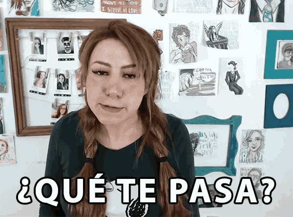 a woman is standing in front of a wall with pictures and says que te pasa