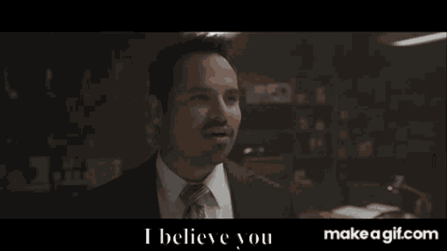 a man in a suit and tie is smiling and says " i believe you "