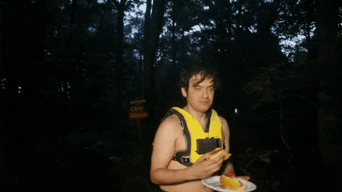 a man wearing a yellow life vest making a face