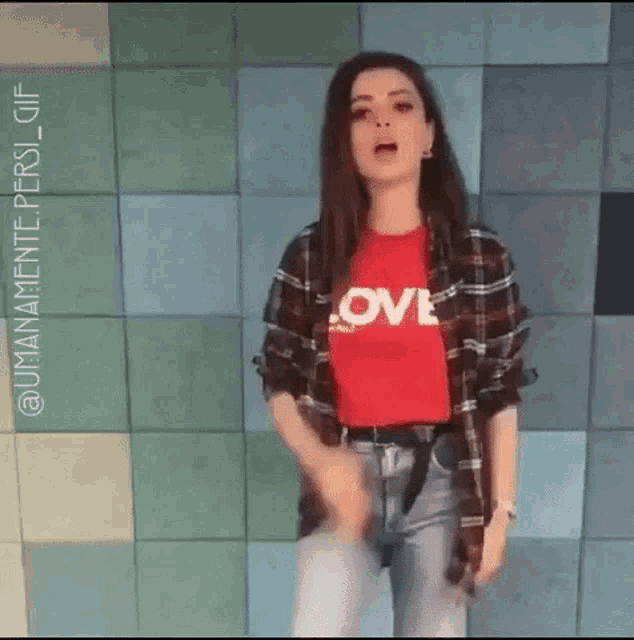 a woman wearing a red t-shirt with the word love on it is dancing .