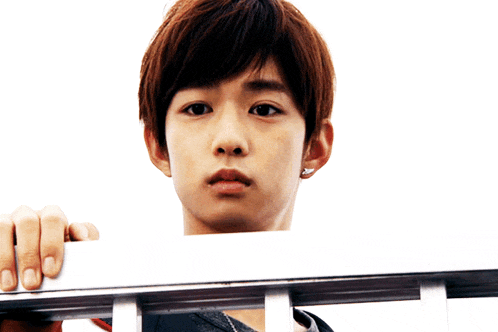 a young man with a necklace around his neck holds a white board