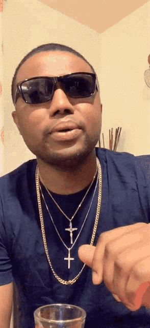 a man wearing sunglasses and a necklace with a cross