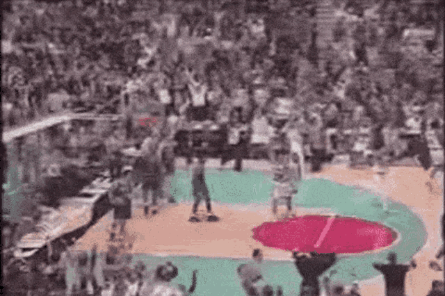 a basketball game is being played on a court with a crowd watching .