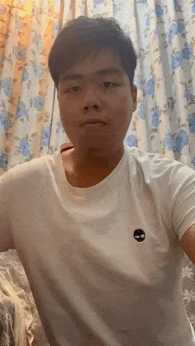 a man wearing a white t-shirt with a timberland logo on the chest