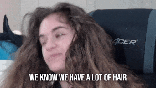 a girl with long hair is sitting in a racer chair