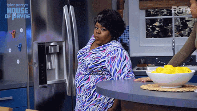 a woman standing in front of a refrigerator that says tyler perry 's house of payne on it