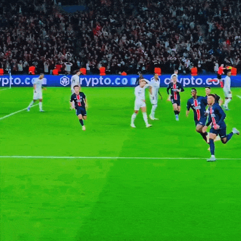 a group of soccer players on a field with a crypto.com banner behind them