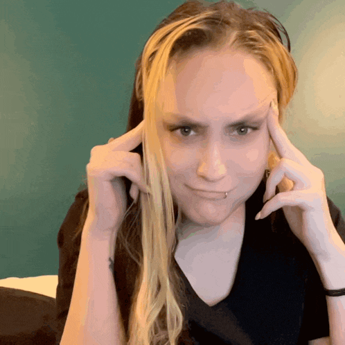 a woman with a piercing on her lip is making a funny face